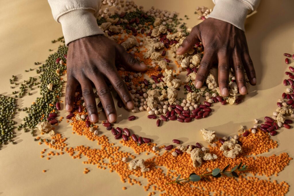 Top view of hands mixing colorful grains and vegan ingredients on a table.